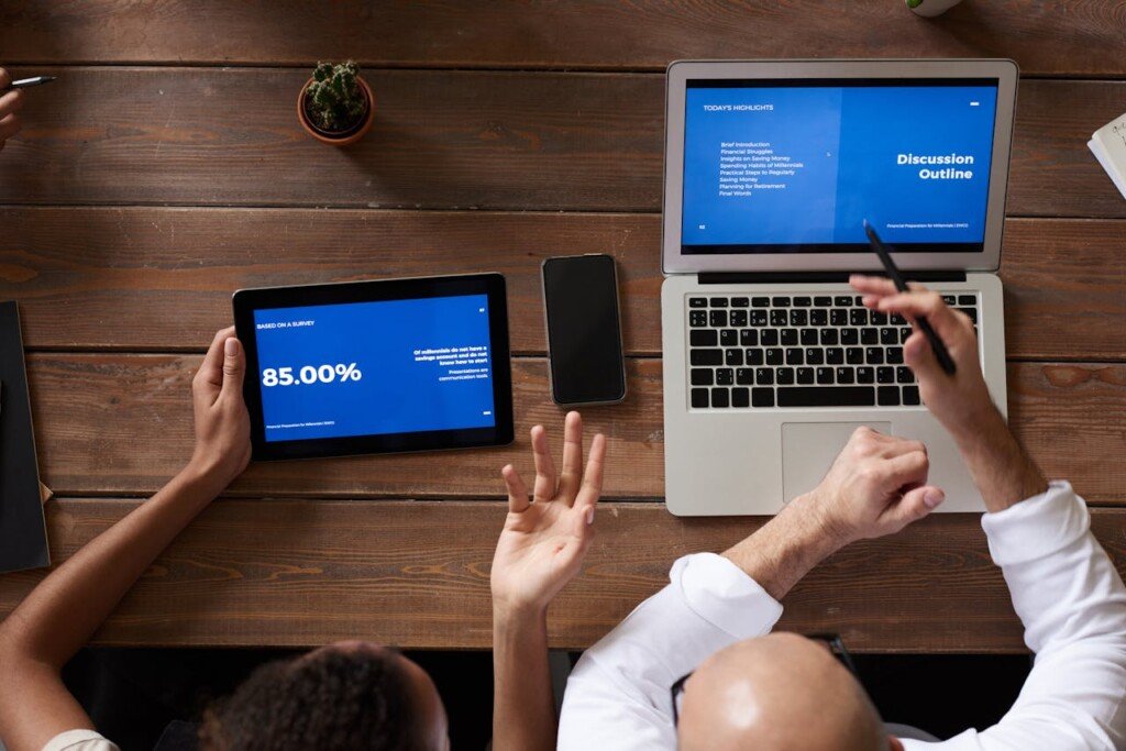 two persons doing analysis of data on a laptop and a pad.