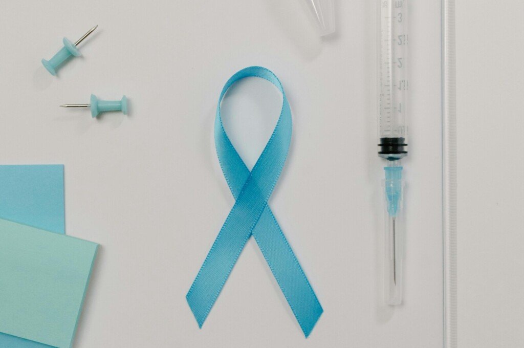 blue ribbon for prostate cancer along with a syringe for needle biopsy